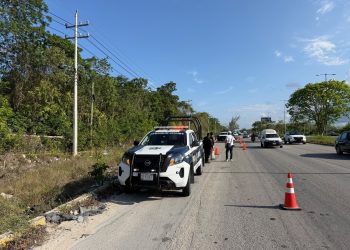 Autoridades resguardan la zona donde encontraron dos cuerpos a un costado de la carretera Puerto Morelos-Cancún.