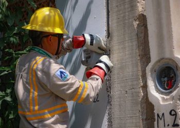 Trabajadores instalan medidores de energía eléctrica en una colonia de Cancún.