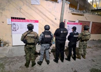 Elementos de la Fiscalía de Quintana Roo durante un cateo en un hotel de Cancún por un caso de presunta trata de personas.