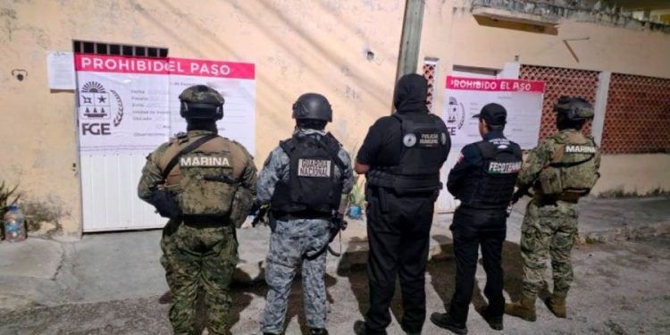 Elementos de la Fiscalía de Quintana Roo durante un cateo en un hotel de Cancún por un caso de presunta trata de personas.