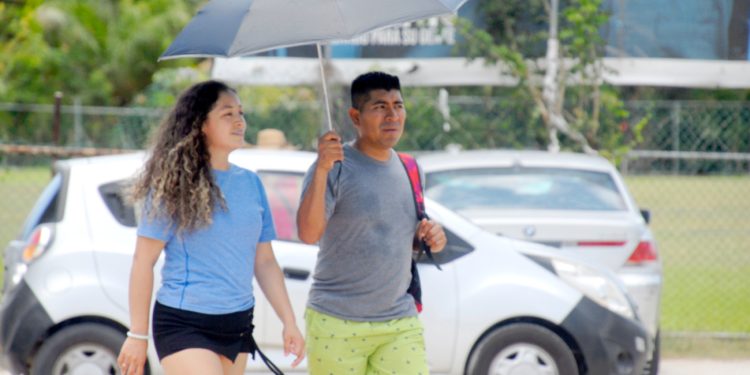 Habitantes de Quintana Roo se protegen del sol durante una ola de calor con sensación térmica superior a 40 grados.