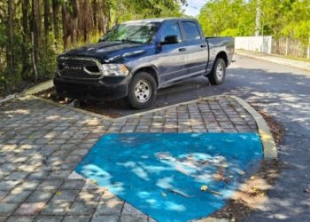 Vehículo de funcionario estacionado en un cajón reservado para personas con discapacidad en Playa del Carmen.