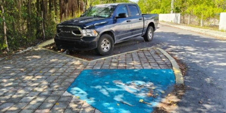 Vehículo de funcionario estacionado en un cajón reservado para personas con discapacidad en Playa del Carmen.